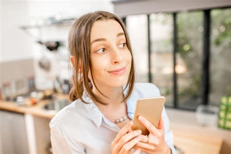 Mujer Joven Con Un Tel Fono Inteligente En La Cocina Foto Premium