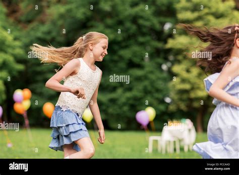 happy girls playing tag game at birthday party Stock Photo - Alamy