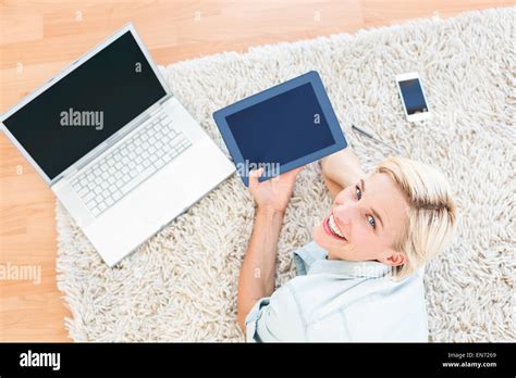 Pretty Blonde Woman Lying On The Floor And Using Her Tablet Stock Photo Alamy