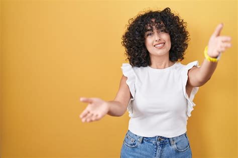 Joven Mujer De Oriente Medio De Pie Sobre Un Fondo Amarillo Mirando A