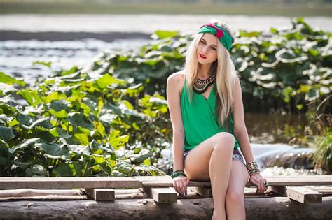 Belle belle fille blonde en short et un bandeau se promène et pose dans le parc Photo Premium