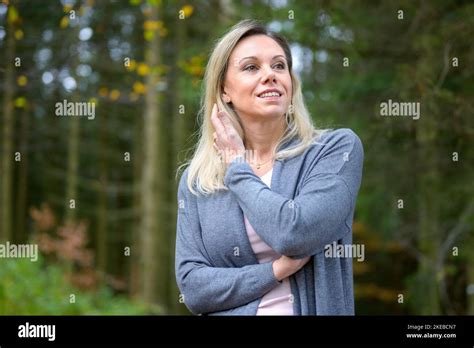 Belle femme blonde d âge moyen douce et souriante passe la main à travers ses cheveux dans la
