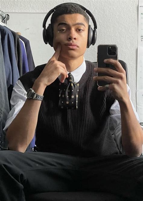 A Man Sitting In Front Of A Mirror Wearing Headphones And Looking At