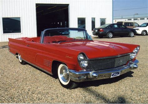 An Old Red Car Parked In Front Of A Building