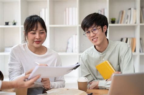 A Group Of Cheerful Asian College Students Is Enjoying Studying Math With A Mature Female