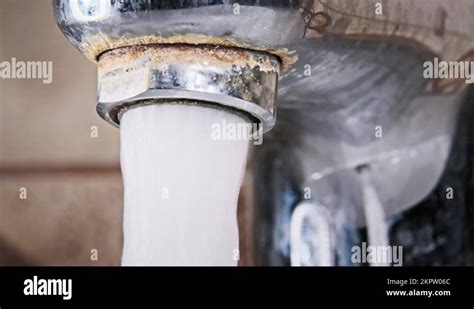 Water Flows From An Old Contaminated Tap With Calcium And Grime Into A