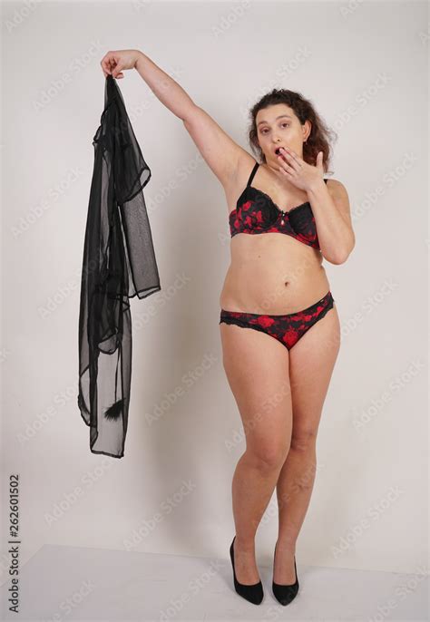 Feminine Chubby Woman With Plus Size Body In Black Lingerie Posing On White Background In Studio