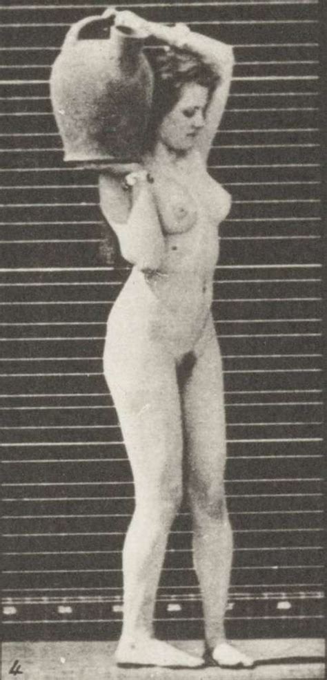 Nude Woman Removing A Water Jar From Shoulder To The Ground And Turning