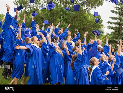 Graduates Tossing Caps In Air At A High School Graduation Ceremony