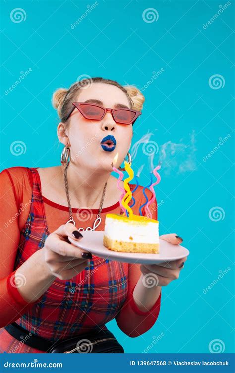 Cheerful Birthday Girl Blowing Candles On Her Delicious Cake Stock