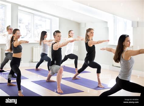 Group Of Sporty People Practicing Yoga Lesson With Instructor Doing