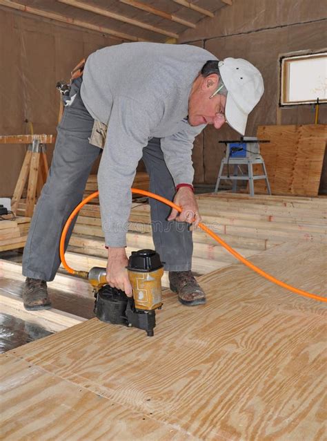 Man Nailing Plywood Floor With Nail Gun Stock Photo Image Of Builder