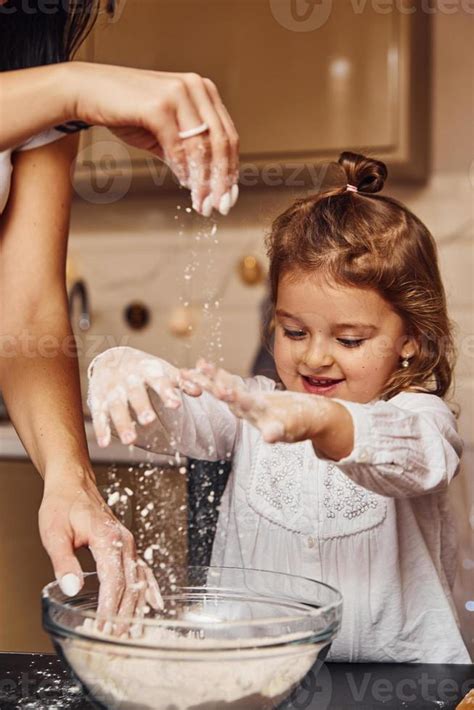 mère avec sa petite fille préparant de la nourriture dans la cuisine et