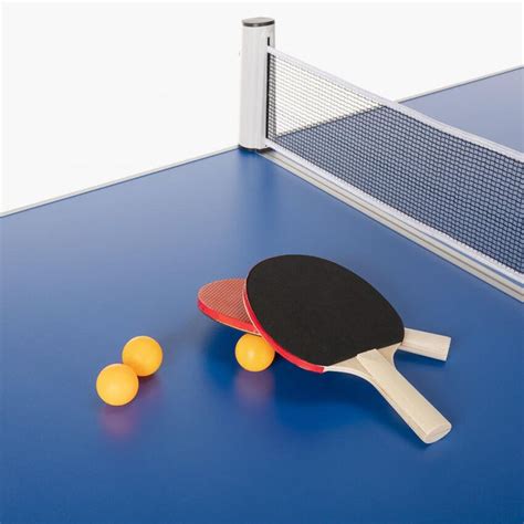 Two Ping Pong Paddles And Three Yellow Balls On A Blue Surface With Net