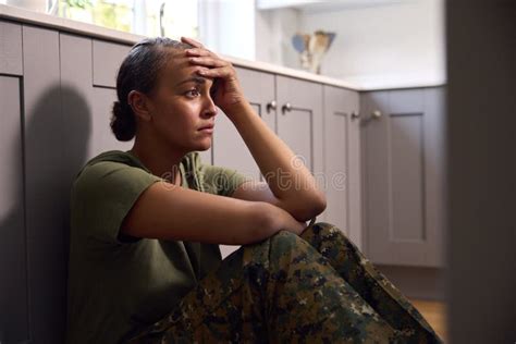 Depressed Female Soldier In Uniform Suffering With Ptsd Sitting On