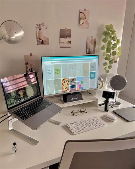 A Laptop Computer Sitting On Top Of A White Desk Next To A Monitor And