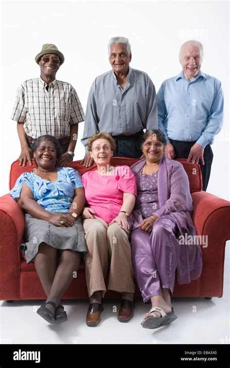 Multiracial Group Of Older People Sitting On A Sofa Together Smiling