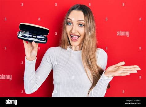 Jeune fille blonde tenant des lunettes célébrant l accomplissement avec le sourire heureux et l
