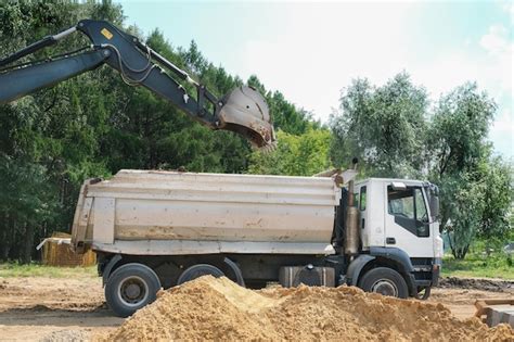 Premium Photo Excavator Loading Truck With Sand