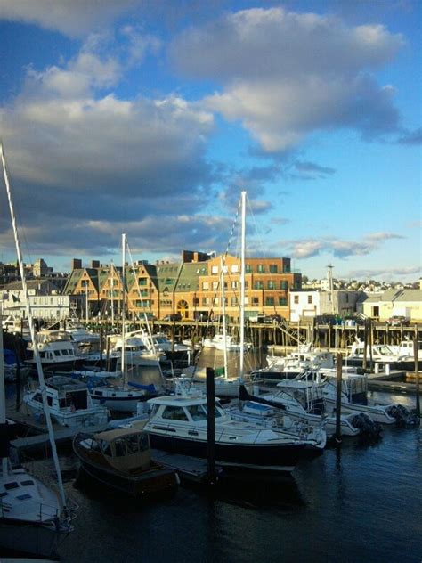 many boats are docked in the harbor on a cloudy day with buildings in ...