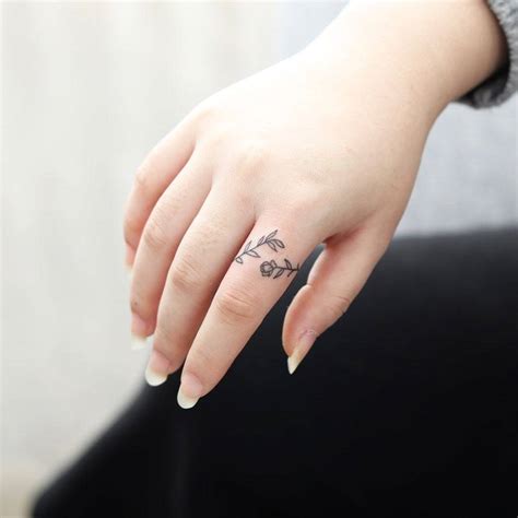 Floral ring tattoo located on the finger.