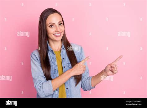 Photo Of Brunette Cool Mature Lady Indicate Empty Space Wear Jeans Jacket Isolated On Pastel