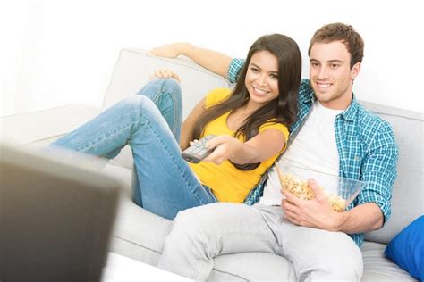 Premium Photo Couple Eating Popcorn While Watching Tv On Sofa