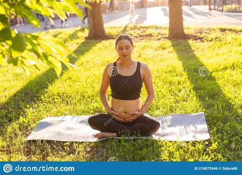 Cute Young Caucasian Pregnant Woman Is Meditating While Sitting On A