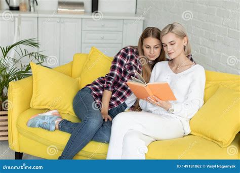 Happy Young Female Lesbian Couple In Casual Clothes Sitting Together On