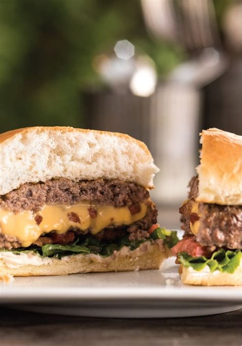 Two Cheeseburgers Are Sitting On A White Plate