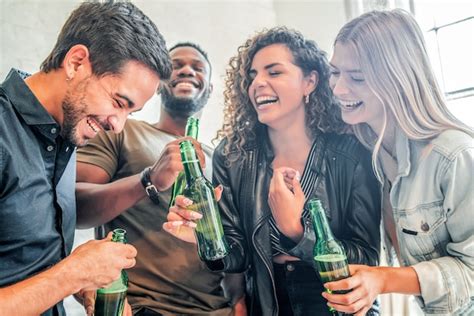 Grupo De Amigos Que Se Divierten Bebiendo Cerveza De Botellas En Una