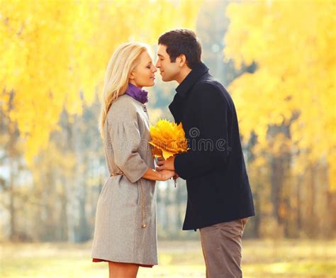 Portrait Young Loving Couple Kissing With Yellow Maple Leafs In Sunny