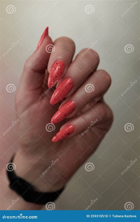 Female Hands With Long Nails And Neon Pink Coral Manicure Stock Photo