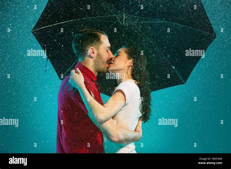 Couple Kissing In The Rain With Umbrella