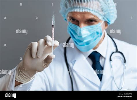 Delighted Doctor Holding Hypodermic Needle Stock Photo Alamy