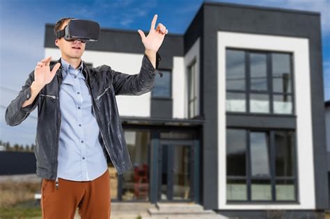 Free Photo | Cheerful man in virtual glasses in front of new house.