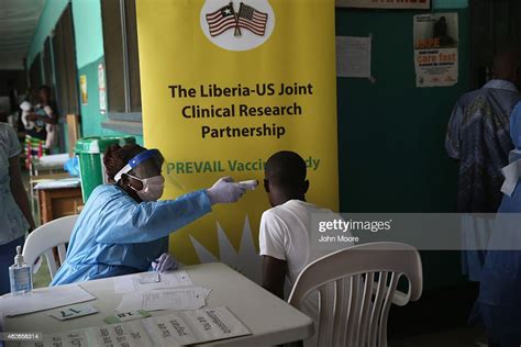 A Nurse Takes The Temperature Of A Volunteer In The Ebola Vaccine