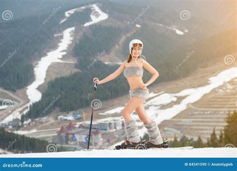 Smiling Naked Woman Is Standing On The Top Of The Slope With Skis Wearing Boots Helmet And