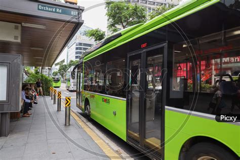 Image Of Commuters Waiting For City Buses At A Bus Stop In Orchard Road