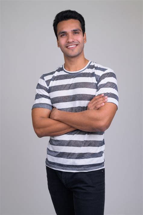 Portrait Of Happy Young Handsome Indian Man Smiling With Arms Crossed