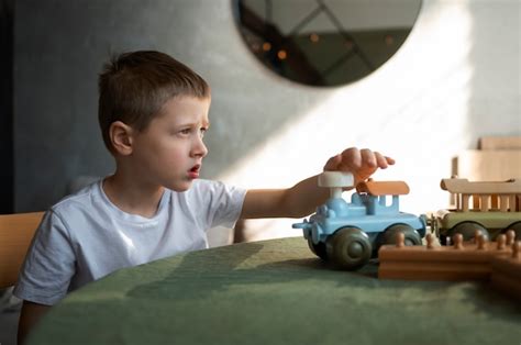 Jeune Garçon Autiste Jouant Avec Des Jouets à La Maison Photo Gratuite