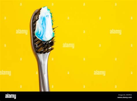 Toothbrush With Black Bristles And White And Blue Paste On A Bright