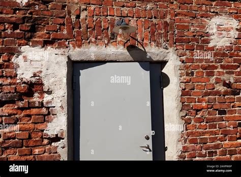 An Old Red Brick Building With New Plate Door And Lighting Stock Photo