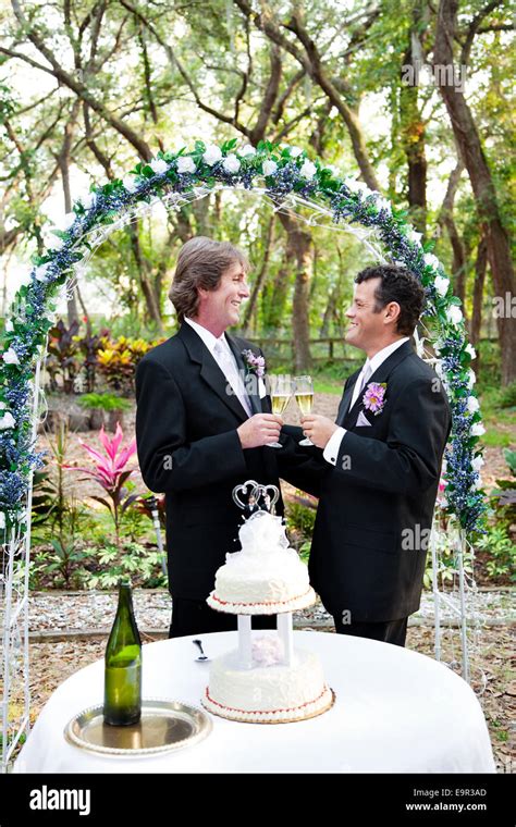Happy handsome gay couple toasting with champagne mariage floral sous arch Gâteau de mariage
