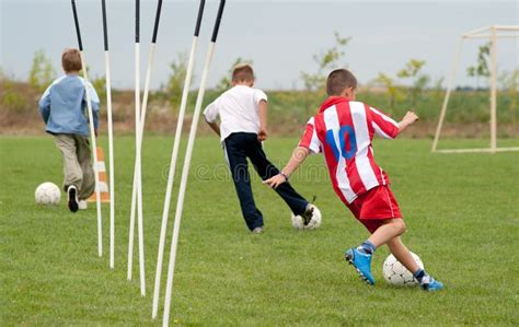 Meninos Que Jogam O Jogo De Futebol Do Futebol No Campo De Esportes