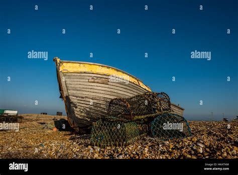 An Abandoned And Derelict Boat On The Beach At Dungeness In Kent Stock