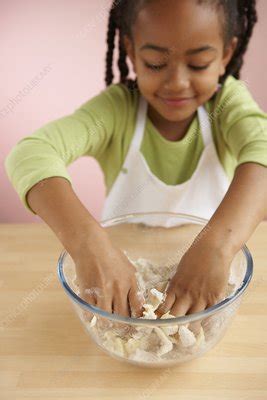 Girl Rubbing Butter Into Flour In Bowl Stock Image C054 1911