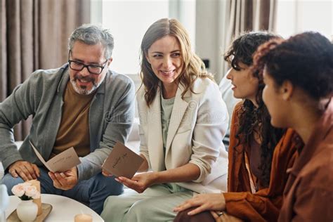 Happy Mature Parents With Wedding Invitations Sitting In Front Of Lesbian Couple Stock Image