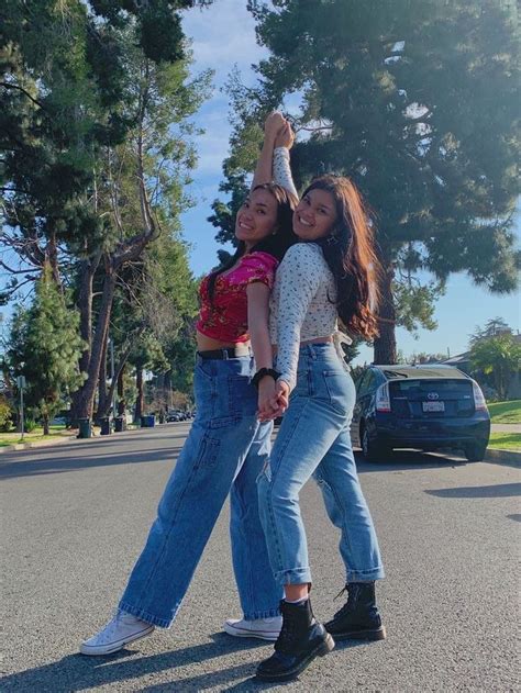 Two Girls Are Standing In The Street With Their Arms Around Each Other