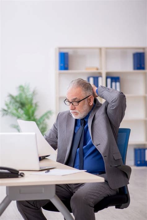 Viejo Empleado De Sexo Masculino Leyendo Papel En El Lugar De Trabajo